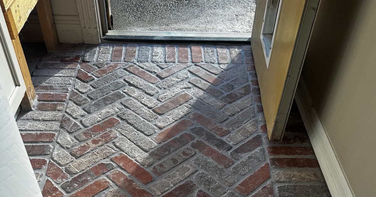 Multi-tone herringbone brick paver laundry room floor with a straight border in White Oak TX