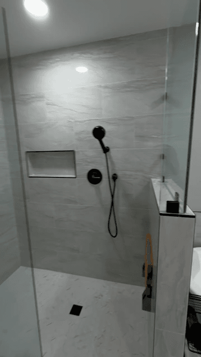 Updated bathroom shower with large-format tile, glass, and clean modern finishes